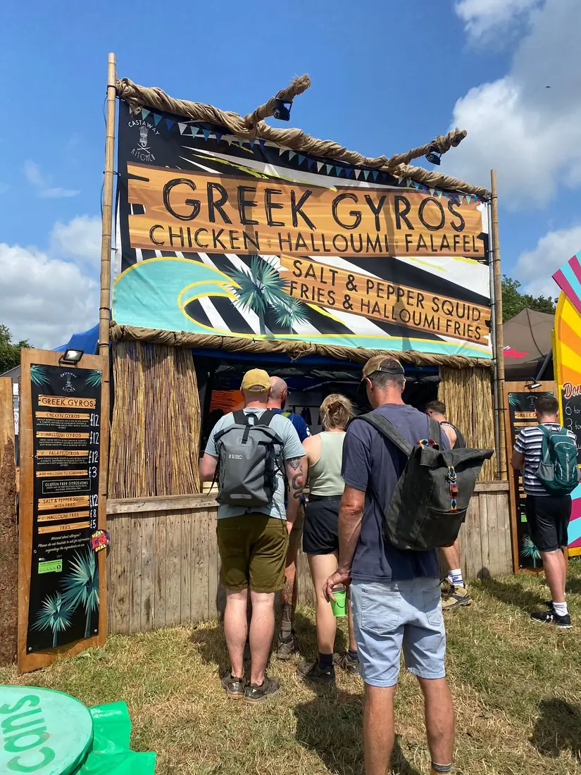Festival-goers queuing in the sunshine at Castaway Kitchen