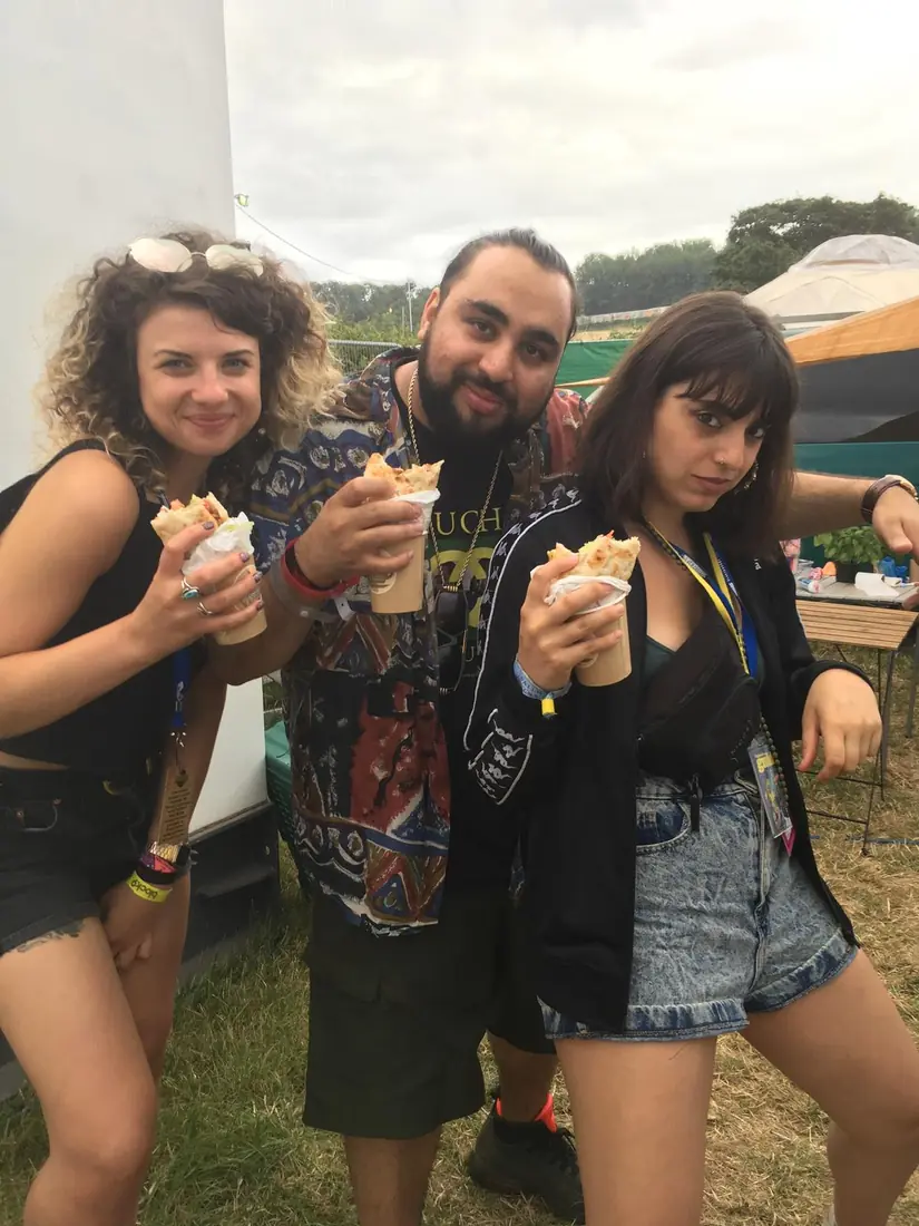 Three festival-goers posing with gyros wraps